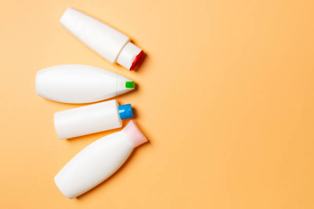 istock Set of White Cosmetic containers isolated on colored background, top view with copy space. Group of plastic bodycare bottle containers with empty space for you design 1275495252