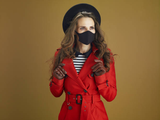 istock modern woman in coat against bronze background 1275500841