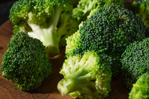 istock Fresh green broccoli on a wooden butt cutting board 1275512985
