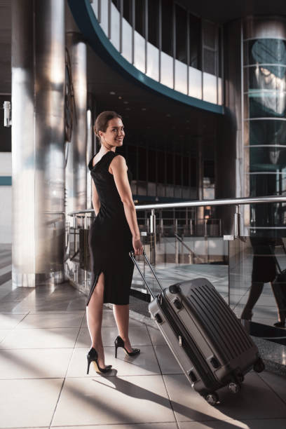 istock Stylish and elegant woman holding her big suitcase 1275521490