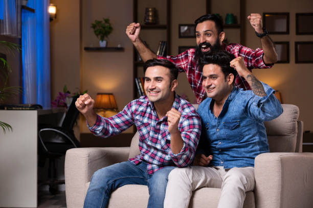 Excited Group Of Friends Sitting On Sofa