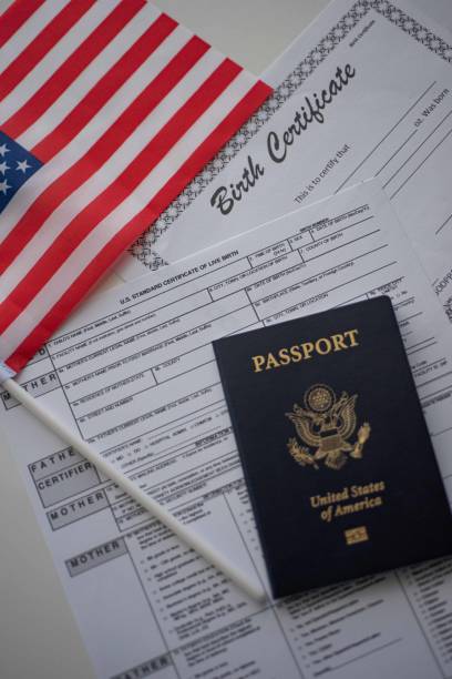 U.S. standard certificate of live birth application form next to American flag, Passport of USA and Birth Certificate template. USA Birthright citizenship concept. stock photo