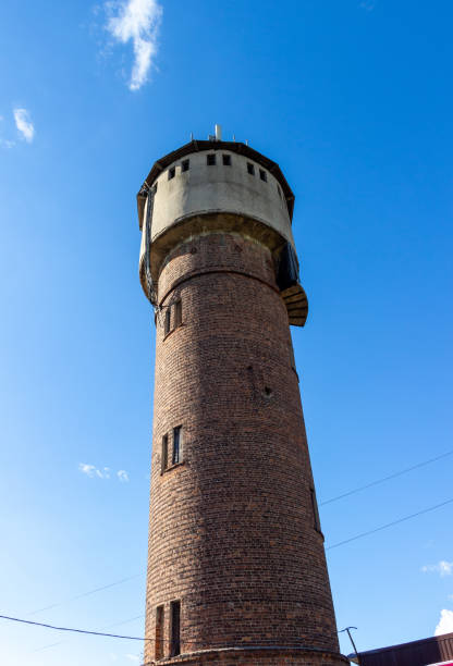 istock Old red brick water tower in sunny day with blue sky 1275581074