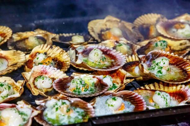 istock Scallops in shells with herbs and seasonings are grilled 1275588752