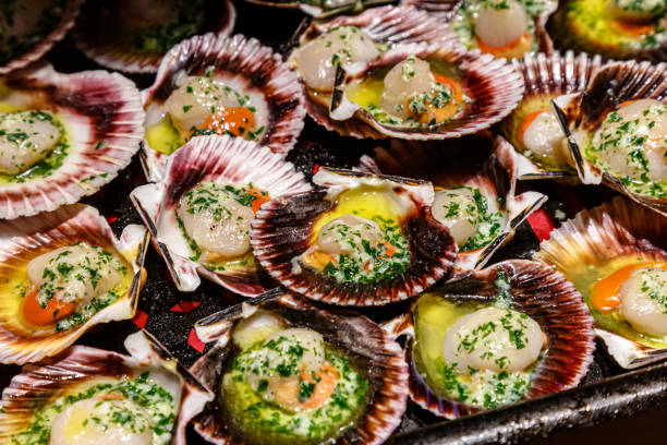 istock Scallops in shells with herbs and seasonings are grilled 1275588888