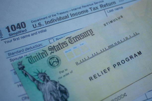 istock Form 1040 U.S. Individual Income tax return next to the Stimulus Check Relief program. Close up view. 1275594763