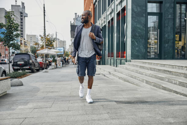 istock Cheerful dark-skinned man walking through the street 1275618227
