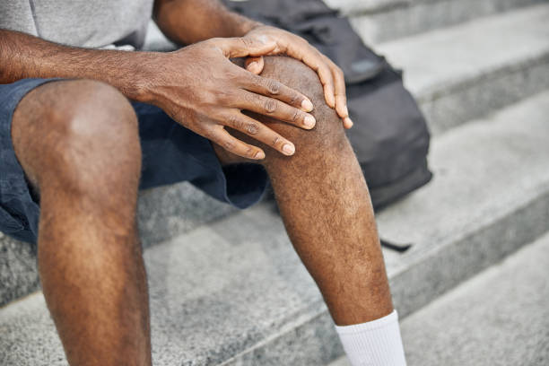 istock Close up of male hands touching knee 1275619404
