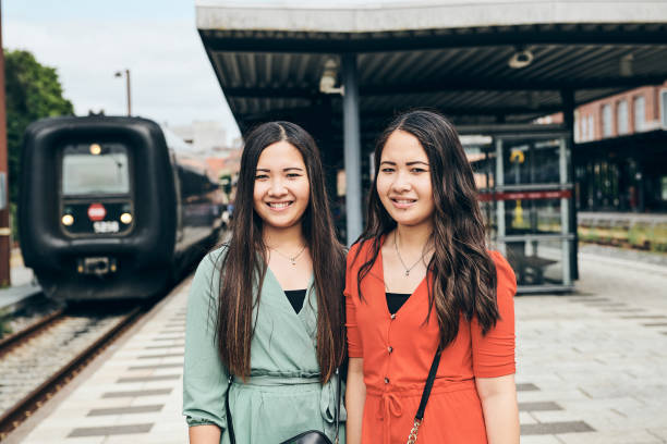 istock Cheerful ethnic ladies on modern railway station 1275627756