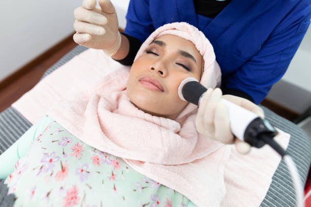 The cosmetologist makes the procedure Microdermabrasion of the facial skin of a beautiful, young woman in a beauty salon The cosmetologist makes the procedure Microdermabrasion of the facial skin of a beautiful, young woman in a beauty salon microdermabrasion stock pictures, royalty-free photos & images