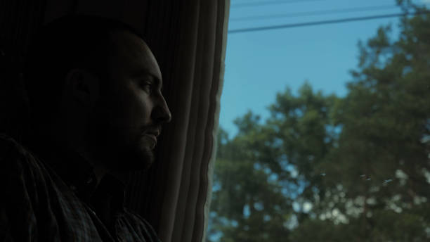 istock Sad young man looking through the window of the train 1275675608