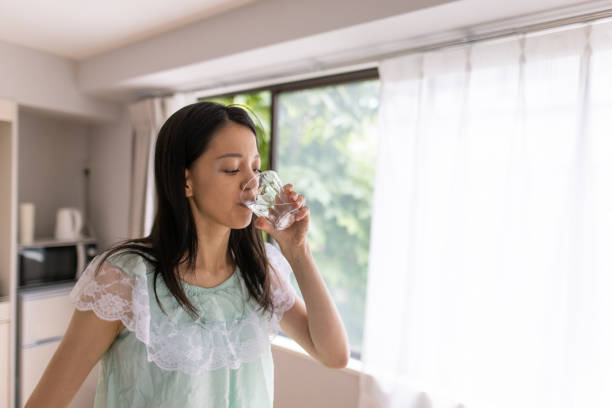 istock Young woman drinking water in the morning 1275675892