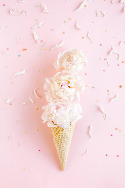 istock Waffle cone with peonies flower on pink background. Flat lay, top view floral background 1275676728