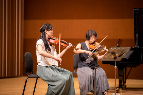 istock Two violinist playing violin together at classical concert 1275676949