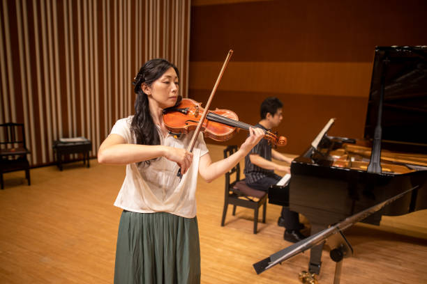 istock Musician playing violin and piano at classical concert 1275677019