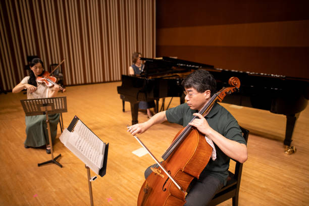 istock Musician playing violin, cell, and piano at classical concert 1275677099