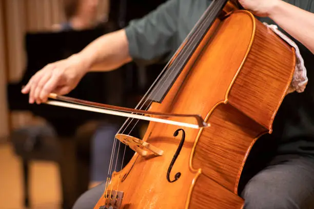 Photo of Close up of cellist playing at classical concert