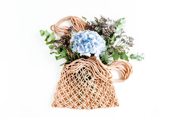 istock Beautiful bouquet of hydrangeas in a string, eco bag on white background. Flat lay, top view 1275677136