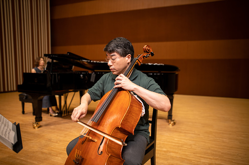 Musician playing cello and piano at classical concert
