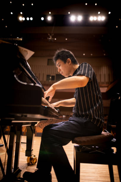 pianista che suona il pianoforte nella sala da concerto - piano men pianist musician foto e immagini stock
