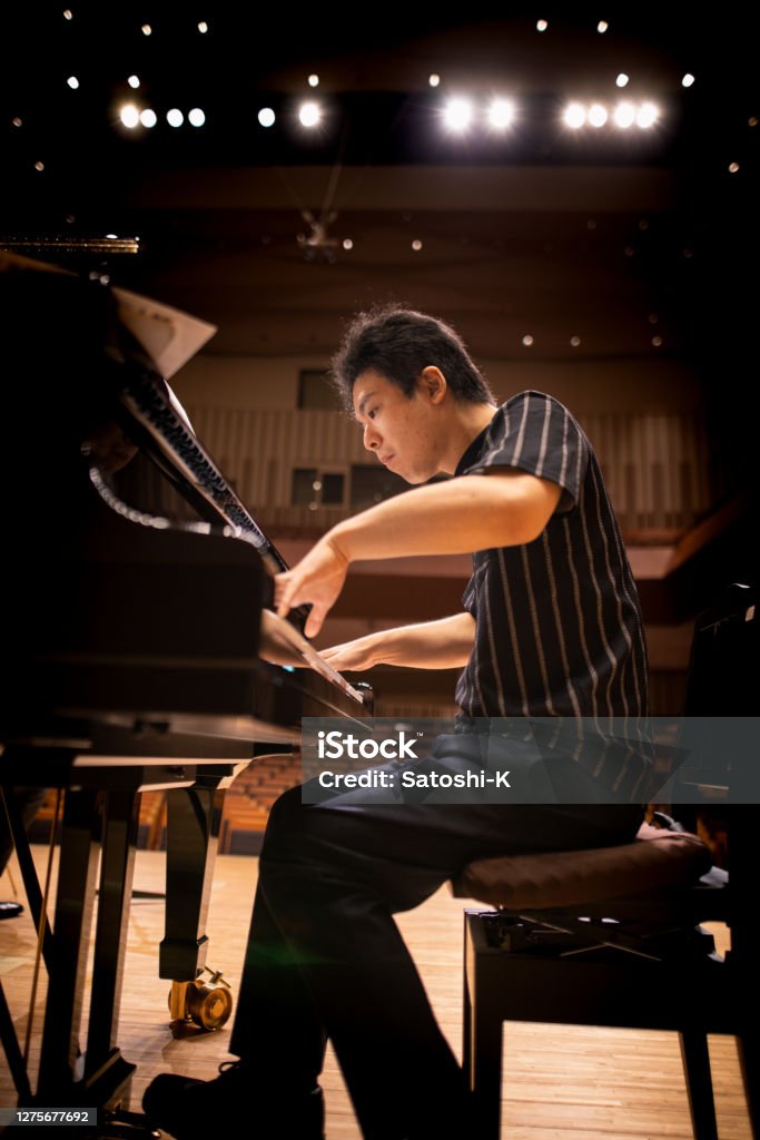 Pianist playing the piano at concert hall Piano Stock Photo