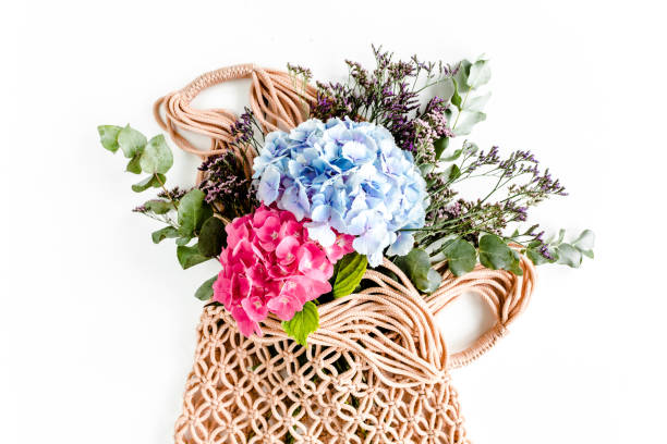 istock Beautiful bouquet of hydrangeas in a string, eco bag on white background. Flat lay, top view 1275679742