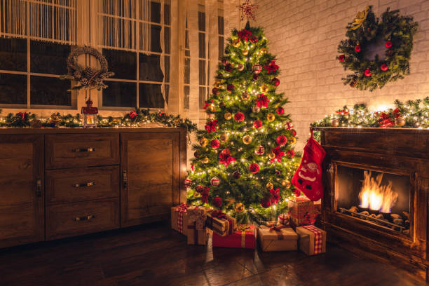 dekorierter weihnachtsbaum in der nähe von kamin zu hause - weihnachtsbaum stock-fotos und bilder