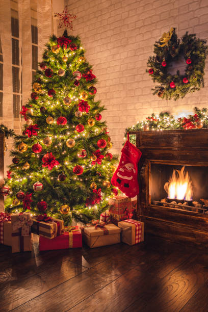 Decorated Christmas Tree Near Fireplace at Home Christmas tree near fireplace in decorated living room red poinsettia vibrant color flower stock pictures, royalty-free photos & images