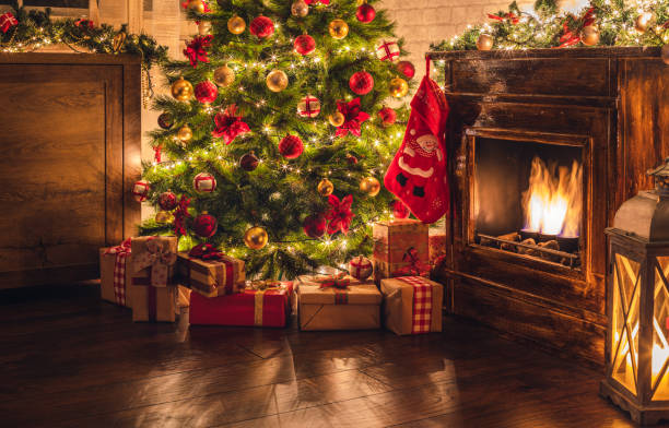 Decorated Christmas Tree Near Fireplace at Home Christmas tree near fireplace in decorated living room red poinsettia vibrant color flower stock pictures, royalty-free photos & images