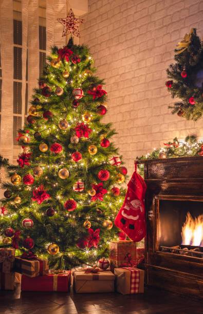 Decorated Christmas Tree Near Fireplace at Home Christmas tree near fireplace in decorated living room red poinsettia vibrant color flower stock pictures, royalty-free photos & images