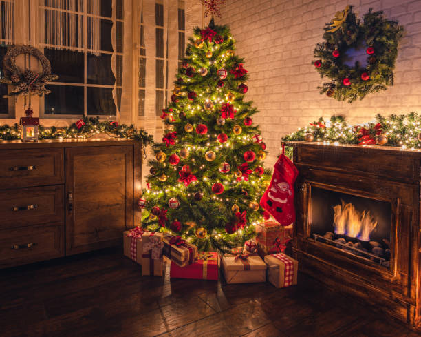 Decorated Christmas Tree Near Fireplace at Home Christmas tree near fireplace in decorated living room red poinsettia vibrant color flower stock pictures, royalty-free photos & images