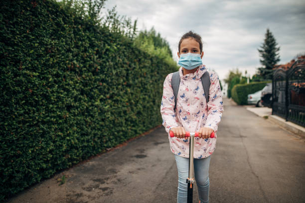 istock Schoolgirl riding push scooter on her way to school 1275682237