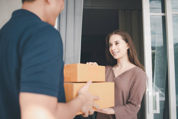 istock deliver man handling package box to female costumer 1275682245