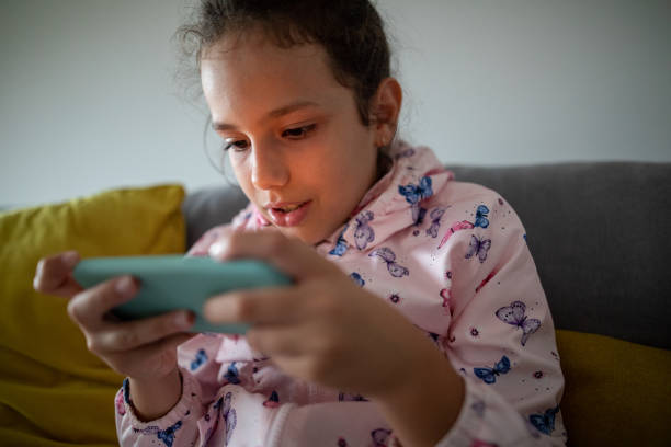 istock Girl is concentrated on playing mobile game at home 1275682278
