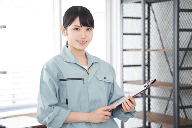 una trabajadora japonesa inspecciona el equipo de una casa - overalls fotografías e imágenes de stock