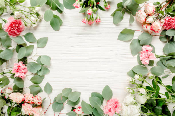 istock frame made of beautiful pink roses and eucalyptus branches on a white background. The apartment lay, top view. Floral frame. Frame of flowers 1275683383