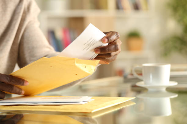 istock Black man hands opens a padded envelope sitting at home 1275685888