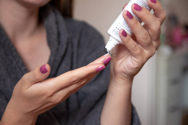 istock Young woman using hand cream at home 1275687043