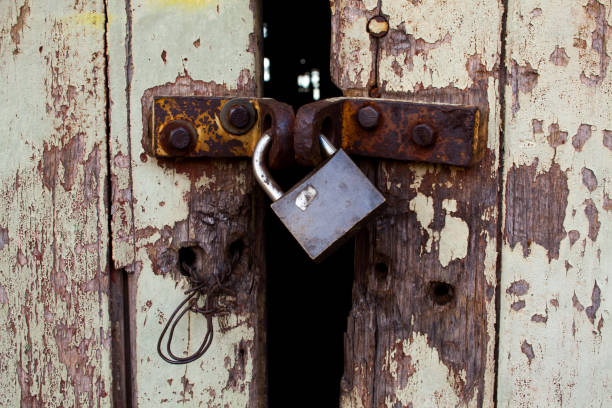 istock Old wood rural door with rusty padlock 1275710798