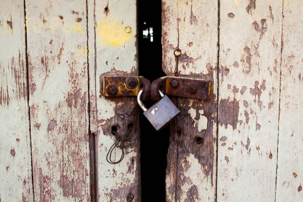 istock Old wood rural door with rusty padlock 1275710878