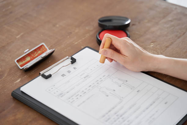 istock A Japanese woman stamps her personal seal on a document 1275711416
