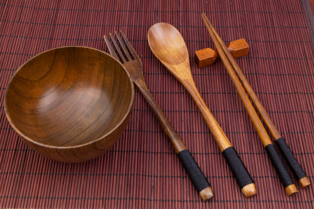 istock Wooden chopsticks, spoon, fork and bowl on bamboo mat 1275712700
