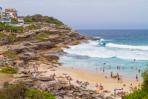 Sydney, Australia - January 1, 2020: People enjoying a summer day in Tamarama Beach, near to Bondi Beach, the day after New Year's Eve.