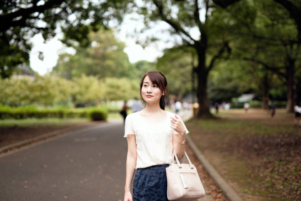 istock Woman walking under trees in park 1275728417