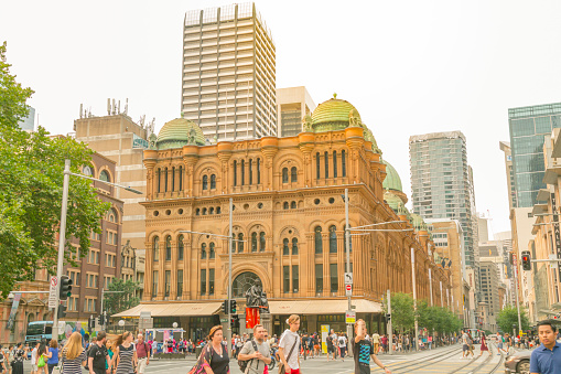 Sydney, Australia - December 31, 2019: People crossing the road outside exterior view of Queen Victoria Building or QVB shopping arcade in Sydney NSW Australia\n\nQueen Victoria building is the 19th ct. heritage listed marketplace, recently renovated and turned into a shopping gallery.\n\nCentral Business District - Queen Victoria Building
