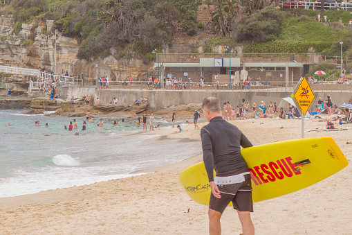 Sydney, Australia - January 1, 2020: Nationals and international tourists enjoying the day, some of them relaxing in front of the sea view, others taking care of them in Bronte Beach, very near beach to Bondi Beach, in the way from Tamarama Beach in Sydney.