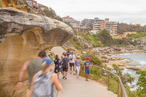 Sydney, Australia - January 1, 2020: Nationals and international tourists enjoying and walking to Clovelly bay beach and Tom Caddy points during Bondi to Coogee coastal walk on a cloudy summer day in Bondi Beach, Sydney, New South Wales, Australia, the day after New Year's Eve.