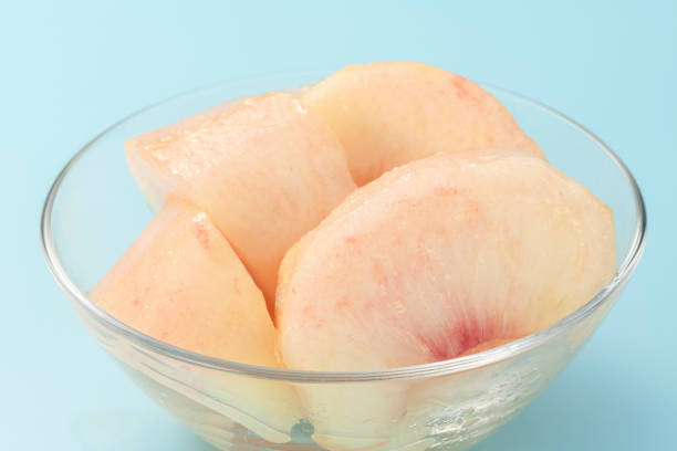 Cut peach on a light blue background. Summer fruits.