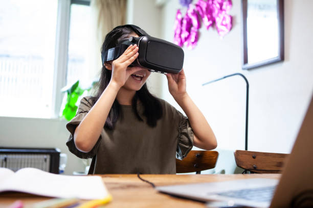 A girl wearing VR goggles and playing on the table A girl wearing VR goggles and playing on the table virtual reality point of view photos stock pictures, royalty-free photos & images