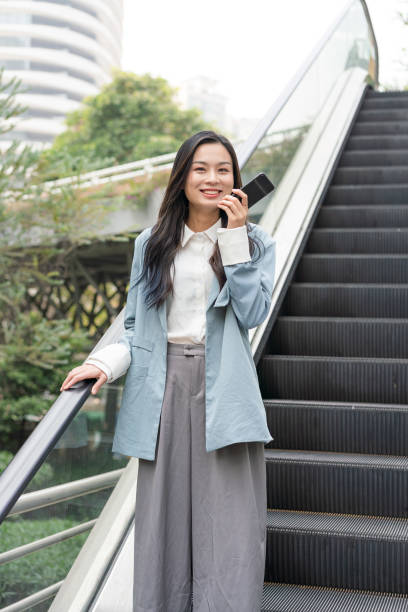 istock A young Asian business woman is using mobile voice messages 1275748336